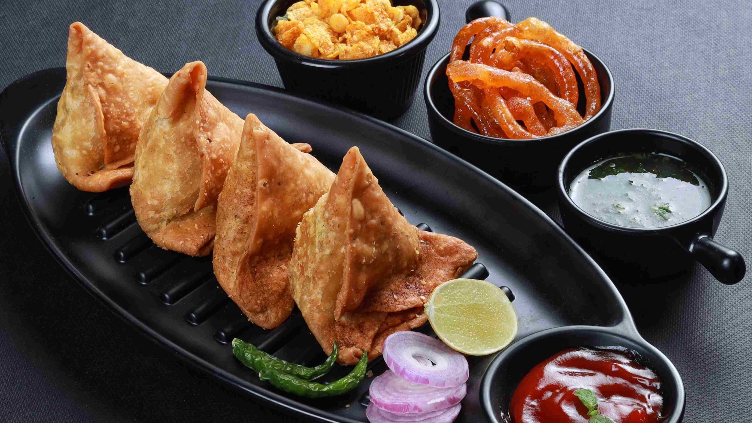 A samosa é um petisco indiano frito e crocante, recheado com ervilhas e batatas apimentadas
